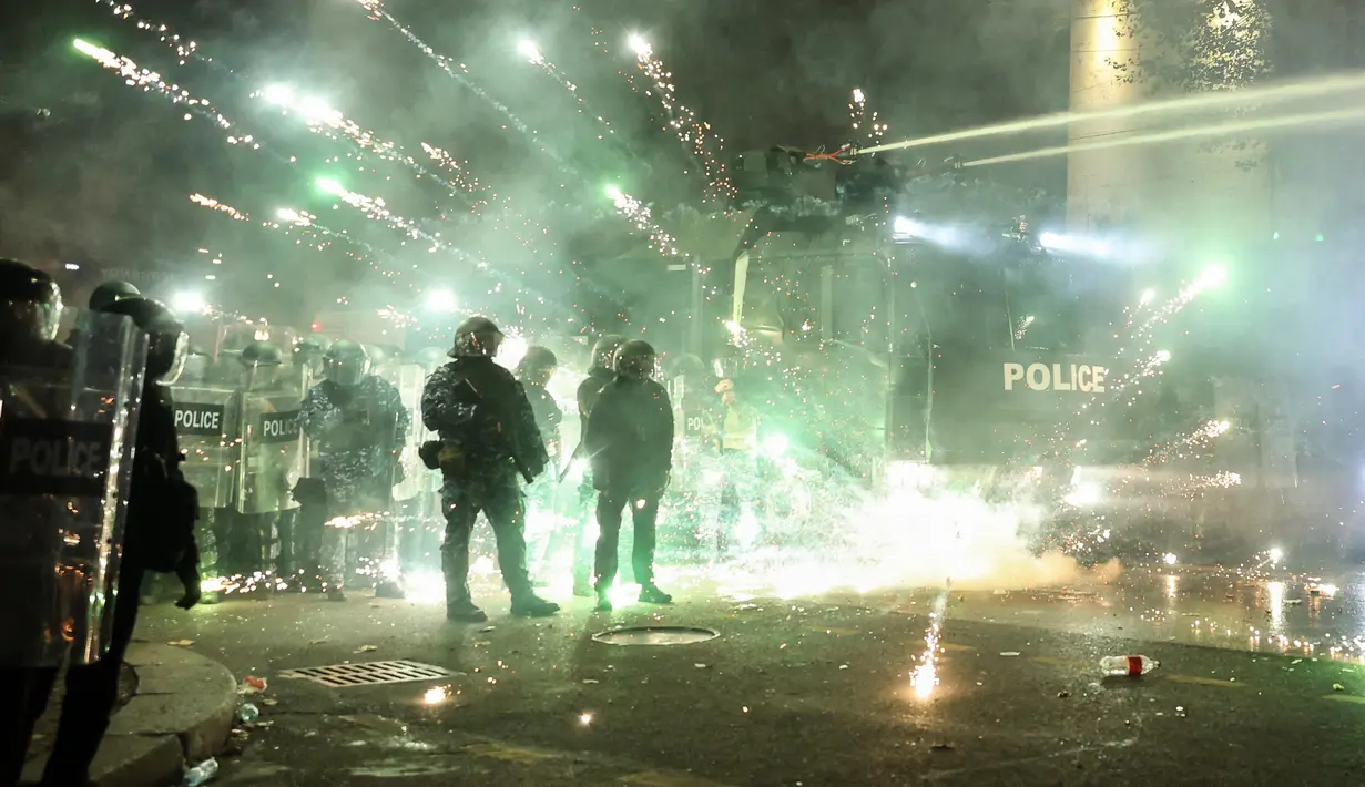 Para pengunjuk rasa menembakkan kembang api ke arah polisi pada hari keempat protes nasional menentang keputusan pemerintah untuk menunda pembicaraan keanggotaan Uni Eropa di Tbilisi pada tanggal 2 Desember 2024. (Giorgi ARJEVANIDZE/AFP)