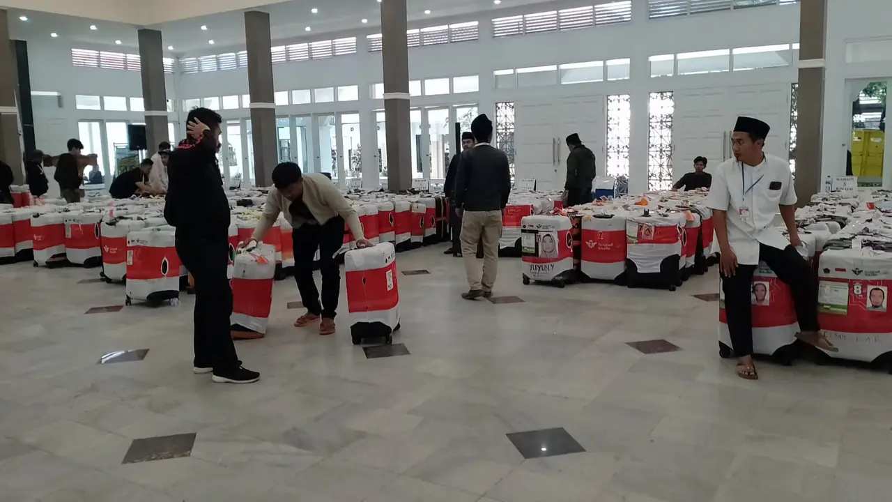 Para perugas haji Kemenag Garut dan perwakilan para KBIH tengah merapihan deretan koper jemaah haji dalam kepulangan gelombang kedua jemaah haji asal Garut. (Liputan6.com/Jayadi Supriadin)