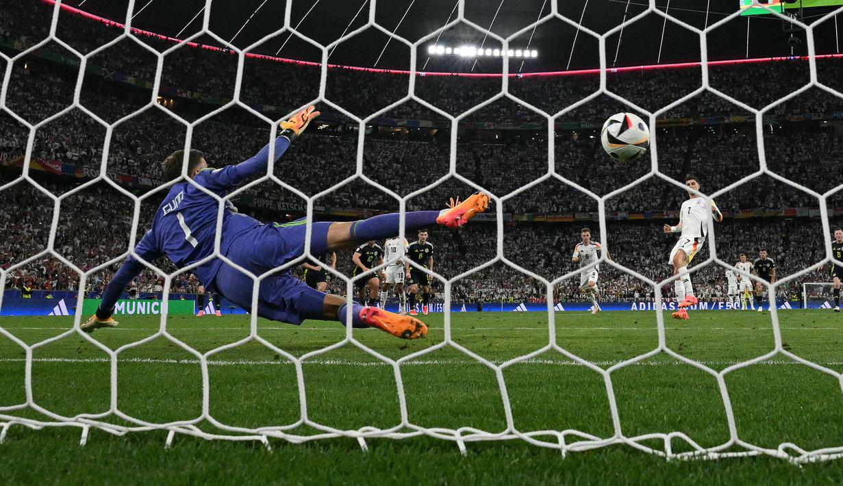 Pemain Jerman, Kai Havertz (kanan) mencetak gol ketiga timnya ke gawang Skotlandia melalui tendangan penalti pada laga pembuka Grup A Euro 2024 di Allianz Arena, Munchen, Jerman, Sabtu (15/06/2024) WIB. (AFP/Miguel Medina)