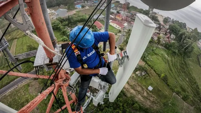 Petugas jaringan XL memeriksa menara BTS XL Axiata yang ada di Danau Toba, Parapat, Sumatera Utara