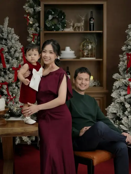 Jessica Tanoesoedibjo juga membagikan foto di depan pohon bersama suami dan putrinya. Jessica mengenakan dress maroon sleeveless polos. [@jessicatanoe]