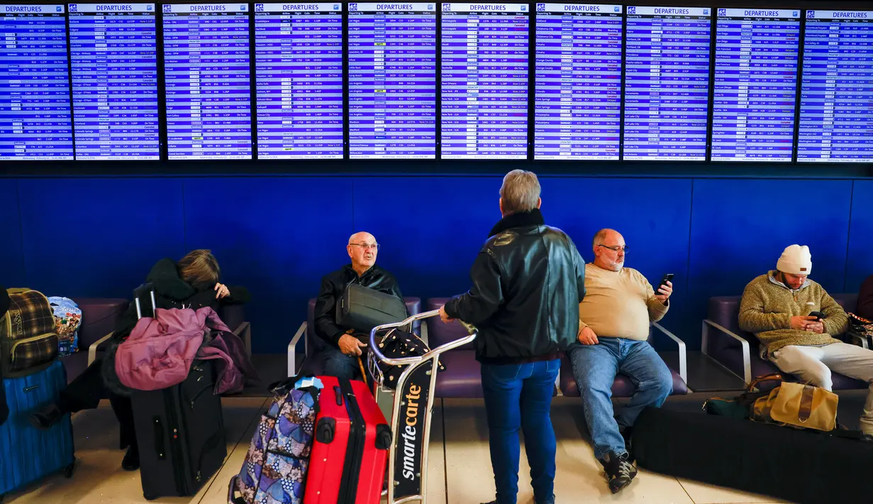 Pelancong melihat papan keberangkatan di Bandara Internasional Denver yang menunjukkan penerbangan yang dibatalkan dan ditunda selama badai musim dingin di Denver, Colorado, Rabu (22/2/2023). Lebih dari 50 juta orang berada di bawah peringatan cuaca musim dingin pada Rabu pagi saat badai bergerak melintasi petak luas Amerika Serikat  bagian barat dan utara dan ke timur. (Michael Ciaglo/Getty Images/AFP)