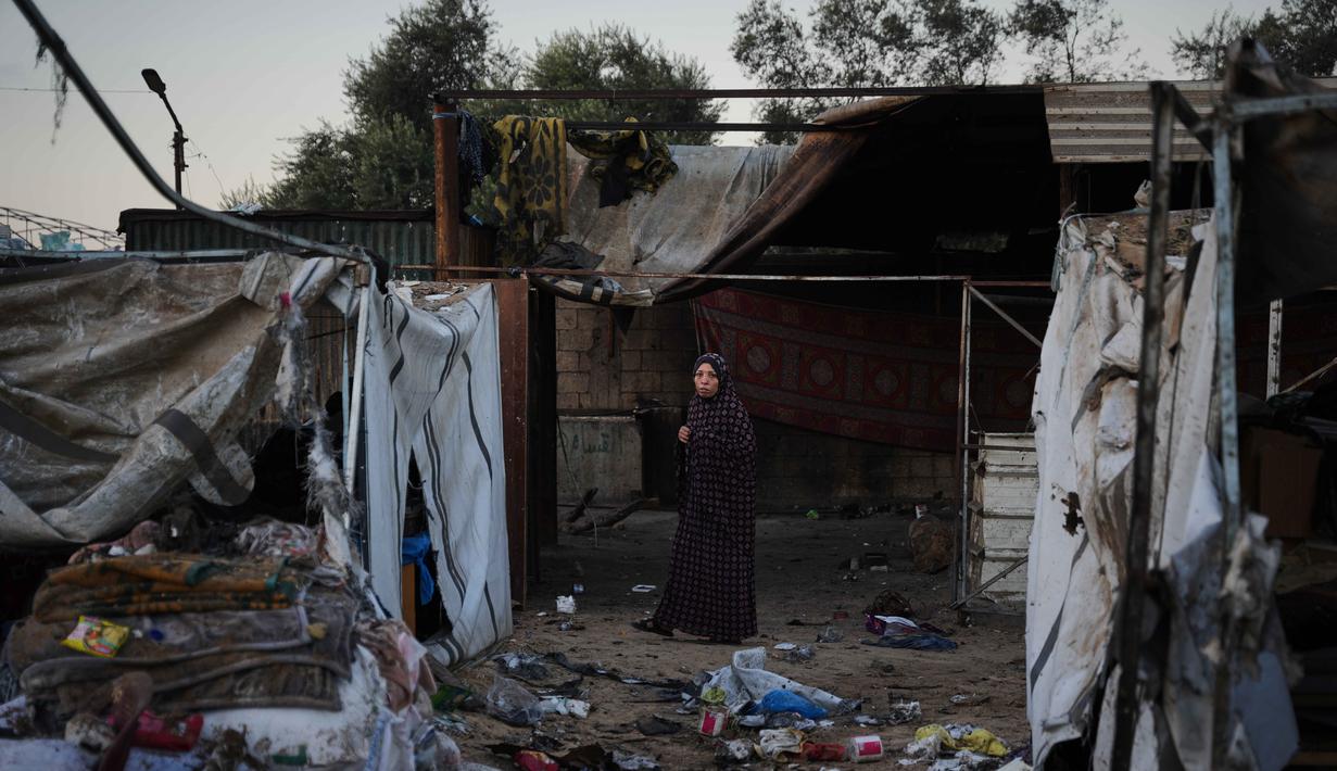 Warga Palestina yang mengungsi memeriksa kerusakan akibat serangan tentara Israel di kamp tenda mereka di Deir al-Balah, Jalur Gaza, Rabu 29 Oktober 2025. Setidaknya, ada 94 warga Palestina meninggal dunia akibat serangan Israel sejak dimulainya gencatan senjata. (AP Photo/Abdel Kareem Hana)