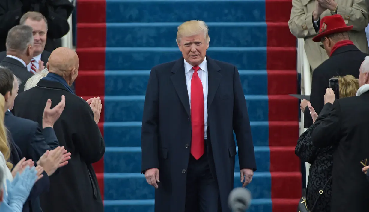 Donald Trump turun menuju podiumnya untuk menyampaikan pidato pertamanya sebagai Presiden AS di Capitol Hill, Washington DC, AS, Jumat (20/1). Dikabarkan, Trump sendiri yang menulis dan menyusun pidato pelantikannya. (AFP Photo)