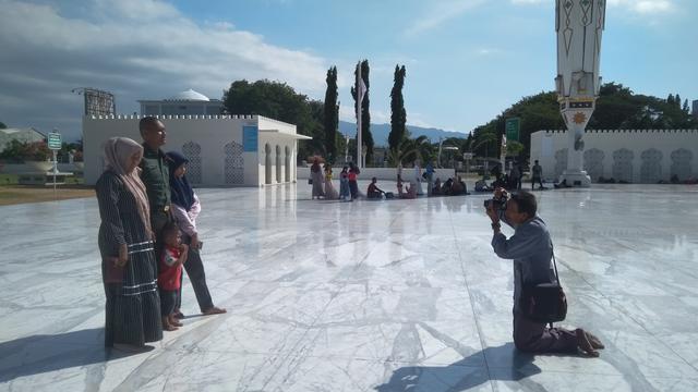 Pengunjung berfoto di pelataran Masjid Raya Baiturrahman (Liputan6.com/Rino Abonita)
