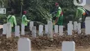 Petugas melakukan perawatan makam jenazah protokol Covid-19 di TPU Srengseng Sawah Dua, Jakarta, Kamis (18/3/2021). Dinkes DKI Jakarta mencatat penambahan kasus kematian akibat Covid-19 pada Maret 2021 berada diatas 40 atau meningkat dari 1,6 menjadi 1,7 persen. (Liputan6.com/Helmi Fithriansyah)