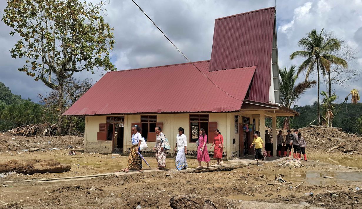 Nuansa sukacita bercampur haru menyelimuti prosesi ibadah Natal di Gereja Protestan Angkola di desa Aek Ngadol, Tapanuli Selatan, Sumatera Utara. Tampak dalam foto, warga desa meninggalkan Gereja Protestan Angkola di desa Aek Ngadol, Tapanuli Selatan, Sumatera Utara, pada Kamis 25 Desember 2025, setelah banjir dan tanah longsor yang melanda di daerah tersebut pada akhir November 2025 lalu. (AMROE/AFP)