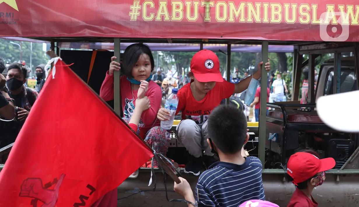 Sejumlah anak terlihat dalam aksi unjuk rasa menolak pengesahan UU Omnibus Law Cipta Kerja di Kawasan Patung Kuda, Jakarta, Jumat (16/10/2020). Meski sudah ada imbauan untuk tidak membawa anak-anak dalam aksi unjuk rasa namun sejumlah orang tua tetap menyertakan. (Liputan6.com/Helmi Fithriansyah)