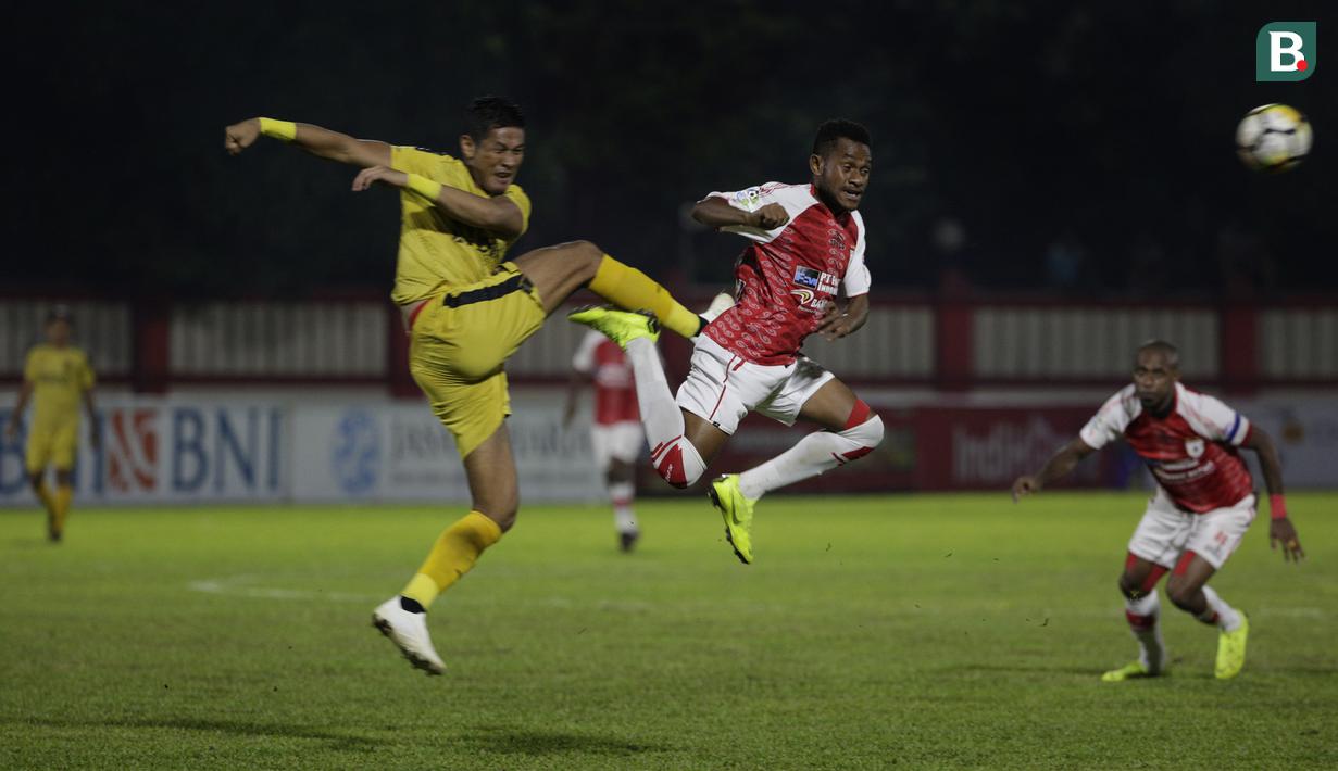 Striker Persipura, Gunansar Mandowen, berebut bola dengan bek Bhayangkara FC, Jajang Mulyana, pada laga Liga 1 Indonesia di Stadion PTIK, Jakarta, Senin (18/11). Bhayangkara menang 2-0 atas Persipura. (Bola.com/Vitalis Yogi Trisna)