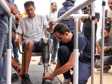 Seorang pria yang mengalami amputasi di atas lutut dipasangi kaki palsu di rumah sakit lapangan Yordania di Khan Yunis di Jalur Gaza selatan pada 17 September 2024. (Bashar TALEB/AFP)