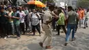 Seorang polisi berusaha memukul fans aktris Bollywood Sridevi Kapoor jelang mendiang, Mumbai, India, Rabu (28/2). (PUNIT PARANJPE/AFP)