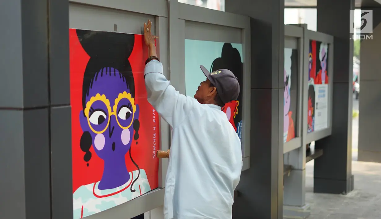 Pekerja memasang karya seni rupa di halte bus Jalan Jenderal Sudirman, Jakarta, Selasa (27/8/2019). Karya seni yang dipajang di halte bus dan stasiun MRT tersebut dibuat dalam rangkaian acara Jakarta Art Week 2019. (Liputan6.com/Immanuel Antonius)