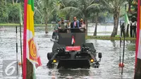 Presiden Joko Widodo berada diatas Panser Anoa Amfibi didampingi Panglima TNI, Gatot Nurmantyo di Mabes TNI, Cilangkap, Senin (16/1). Panser tersebut melintasi danau Mabes TNI menuju Gedung Aula Gatot Subroto. (Liputan6.com/Angga Yuniar)