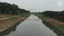 Anak-anak melintasi penyaring sampah untuk menyeberangi Kanal Banjir Timur di Jakarta, Kamis (28/12). Meski tidak aman bagi keselamatan, warga memanfaatkan penyaring sampah tersebut untuk menyebrang. (Liputan6.com/Immanuel Antonius)