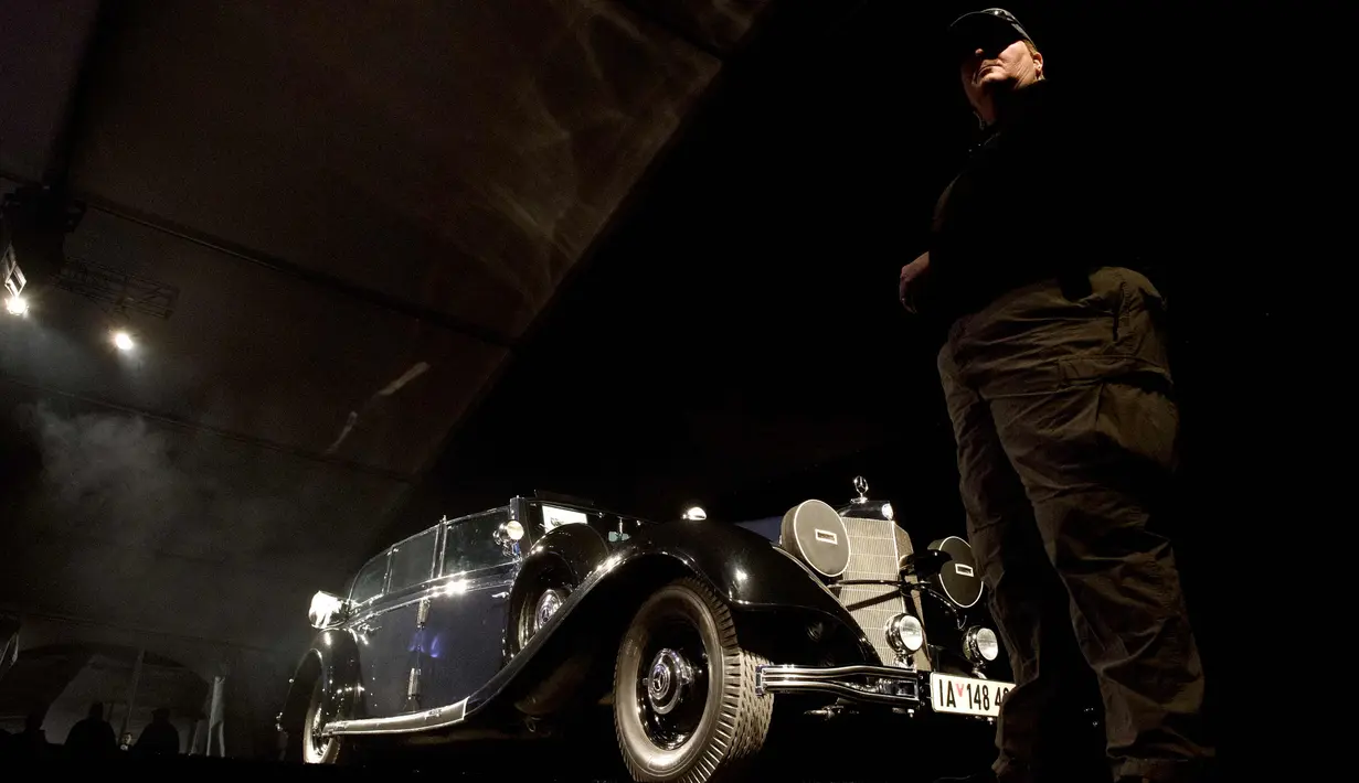 Petugas berjaga di dekat mobil Mercedes-Benz 770K Grosser Open Tourer milik Adolf Hitler yang di Scottsdale, Arizona, AS, (17/1). Tawaran tertinggi mobil ini mencapai USD 7 juta, atau senilai Rp 93 miliar. (AFP Photo/Laura Segall)