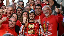Francesco Bagnaia, merayakan keberhasilan dirinya sebagai juara dunia MotoGP 2023 bersama pujaan hati dan seluruh satf Ducati setelah finis posisi pertama pada balapan MotoGP Valencia hari Minggu (26/11/2023). (AFP/Javier Soriano)
