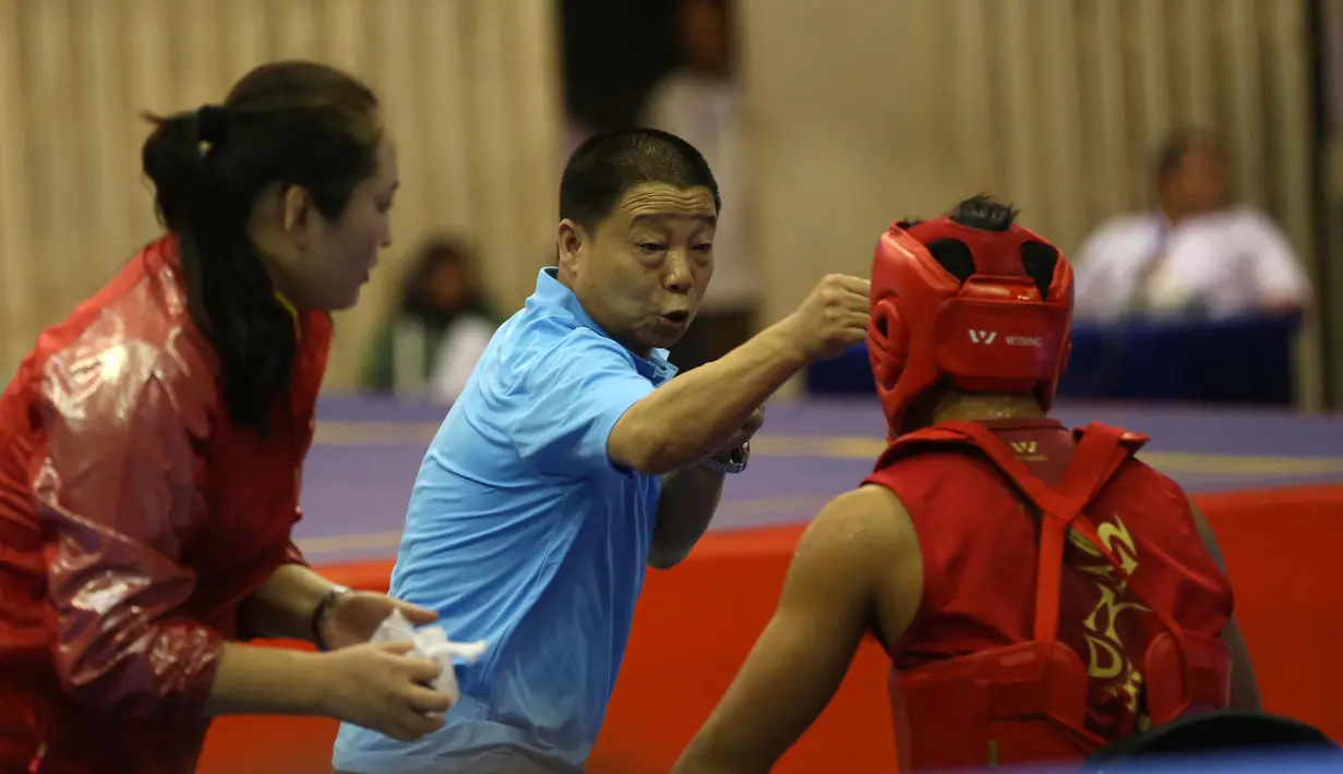 Atlet Wushu Asal China, mendengar instruksi pelatihnya pada Cabang Sanda Kejuaraan Dunia Wushu 2015 di Istora, Senayan, Jakarta,Rabu (18/11/2015). (Bola.com/Nicklas Hanoatubun)