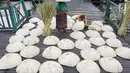 Dua orang wanita membuat caping khas Banjar di kawasan Pasar Apung Kuin, Kalimantan Selatan, Senin (26/3). Caping atau tanggui ini merupakan topi tradisional khas Banjar yang terbuat dari daun nipah. (Liputan6.com/Immanuel Antonius)