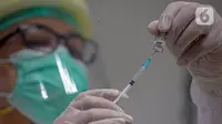 Vaksinator menyiapkan vaksin COVID-19 sebelum menyuntikkannya kepada Wakil Menteri Kesehatan Dante Saksono Harbuwono di RSCM, Jakarta, Kamis (14/1/2021). Menurut Menteri Kesehatan Budi Gunadi Sadikin, tahap awal program vaksinasi akan menyasar tenaga kesehatan. (Liputan6.com/Faizal Fanani)