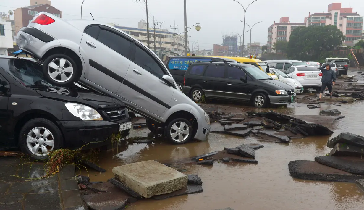 Sejumlah mobil dalam posisi porak-poranda dan bertumpuk disepanjang jalan setelah dihantam topan Chaba yang menerjang Pulau jeju, Korsel, Rabu (5/10). Sedikitnya 2.500 sekolah di wilayah selatan negara itu ditutup akibat topan ini. (YONHAP/AFP)