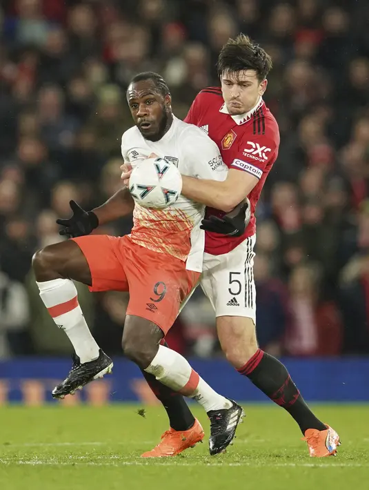 Bek Manchester United atau MU Harry Maguire berebut bola dengan penyerang West Ham Michail Antonio pada putaran kelima Piala FA di Old Trafford, Kamis (2/3/2023) dinihari WIB. MU yang sempat tertinggal mampu membalas lewat tiga gol. Semua gol lahir pada babak kedua. (AP Photo/Dave Thompson)