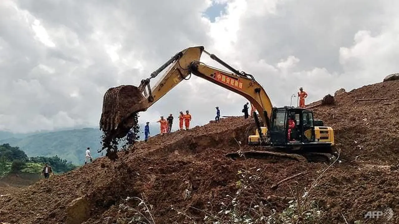 Sebuah ekskavator dan penyelamat bekerja di lokasi tanah longsor di Liupanshui, Provinsi Guizhou, Barat Daya China, 24 Juli 2019. (AFP / STR)