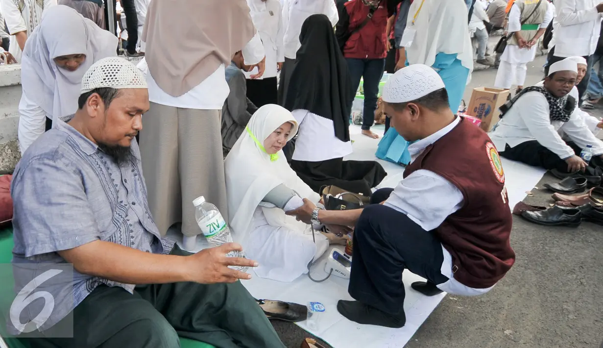 Sejumlah tim membantu demonstran yang kelelahan saat melakukan demo di depan Balai Kota, Jakarta, Jumat (4/11). Massa yang datang ke posko ini rata-rata yang usianya sudah separuh baya, di atas 45 tahun. (Liputan6.com/Yoppy Renato)