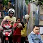 Pengendara motor melintas ketika sejumlah bocah bermain bola di gang kecil kawasan Benhil, Jakarta, Rabu (10/6). Gang kecil itu dimanfaatkan untuk bermain dikarenakan minimnya sarana bermain khususnya lapangan bola di Jakarta. (Liputan6.com/Johan Tallo)