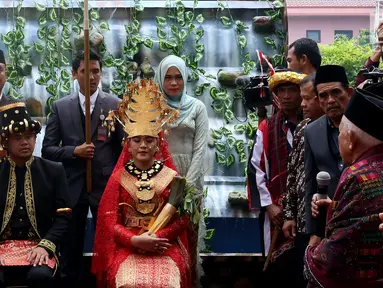 Pasangan Kahiyang Ayu dan Bobby Nasution saat mengikuti prosesi Pesta Adat di Bukti Hijau Regency, Taman Setia Budi, Medan, Sabtu, (25/11). Kahiyang mengenakan baju kebaya warna merah dipadukan dengan songket dan mahkota emas. (Liputan6.com/Johan Tallo)