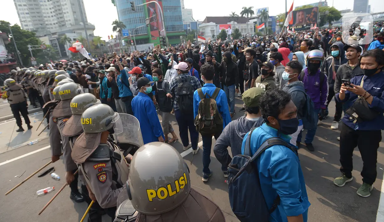 Aparat kepolisian menjaga massa aksi di kawasan Harmoni, Jakarta, Kamis (8/10/2020). Bentrokan pecah saat massa yang hendak menuju Istana Negara untuk menggelar unjuk rasa menolak UU Cipta Kerja diadang oleh aparat kepolisian. (merdeka.com/Imam Buhori)