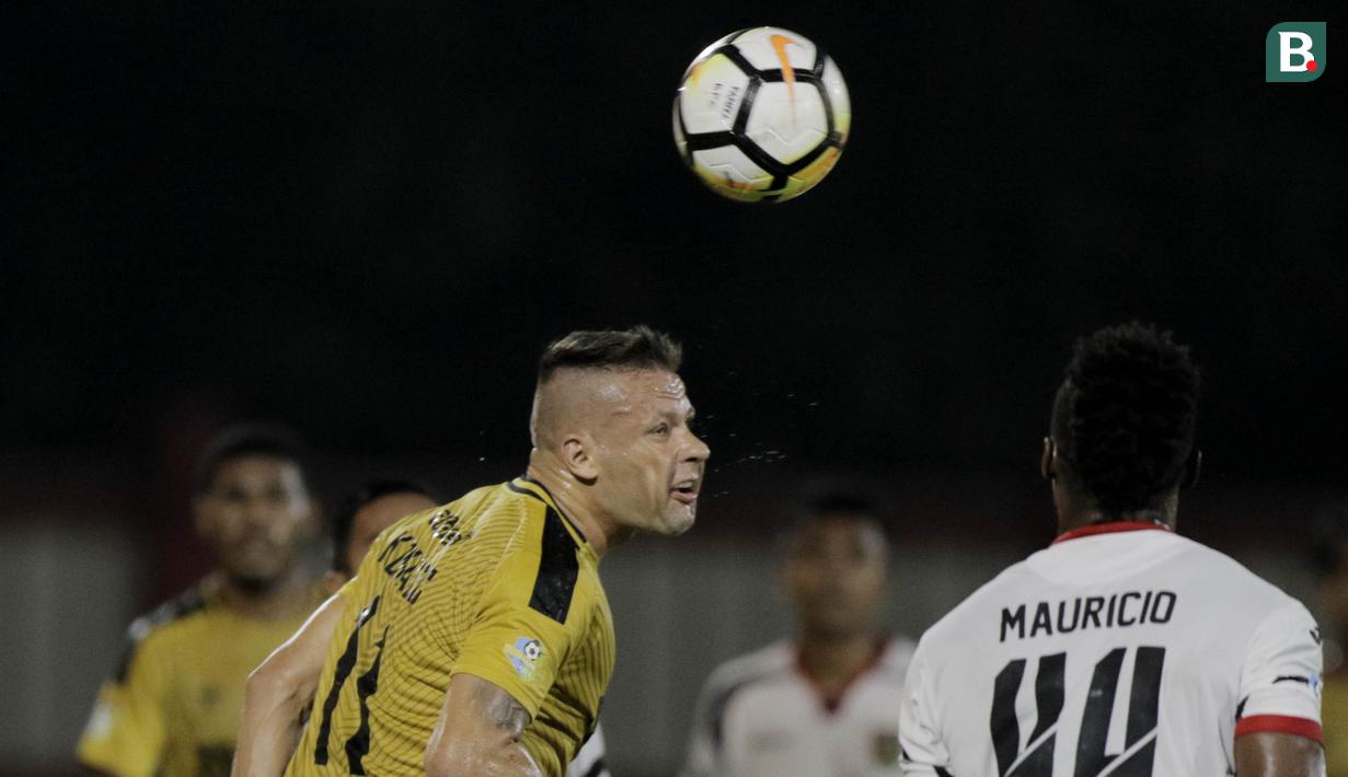 Striker Bhayangkara FC, Nikola Komazec, duel udara dengan bek Mitra Kukar, Mauricio Leal, pada laga Liga 1 di Stadion PTIK, Jakarta, Kamis (17/5/2018). Bhayangkara FC menang 1-0 atas Mitra Kukar. (Bola.com/M Iqbal Ichsan)