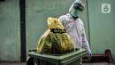 Petugas mengenakan APD saat membawa kantong berisi limbah Covid-19 ke Tempat Penyimpanan Sementara Limbah B3 di Laboratorium Kesehatan Daerah (Labkesda) DKI Jakarta, Selasa (4/8/2020). Pembuangan limbah Covid-19 dilakukan dengan proses ketat sesuai protokol kesehatan. (merdeka.com/Iqbal Nugroho)