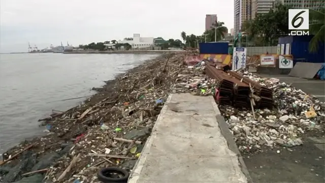 Pembersih dan sukarelawan menyapu tumpukan sampah yang ditinggalkan oleh Topan Mangkhut di sepanjang Teluk Manila, Minggu (16/9).