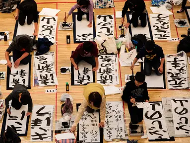 Peserta berkompetisi menjadi yang terbaik dalam kontes kaligrafi  tahun baru di Tokyo, Jepang, Sabtu (5/1). Kontes yang diikuti ribuan peserta ini digelar untuk merayakan Tahun Baru 2019. (Behrouz MEHRI / AFP)