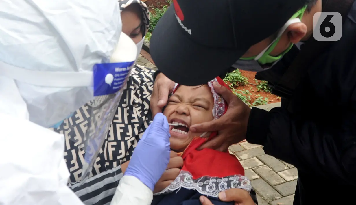 Ekspresi seorang anak saat menjalani swab test massal di Puskesmas Ciganjur, Jakarta Selatan, Kamis (7/1/2020). Swab test gratis tersebut dilakukan untuk screening memetakan penyebaran COVID-19 di Kelurahann Ciganjur. (merdeka.com/Arie Basuki)