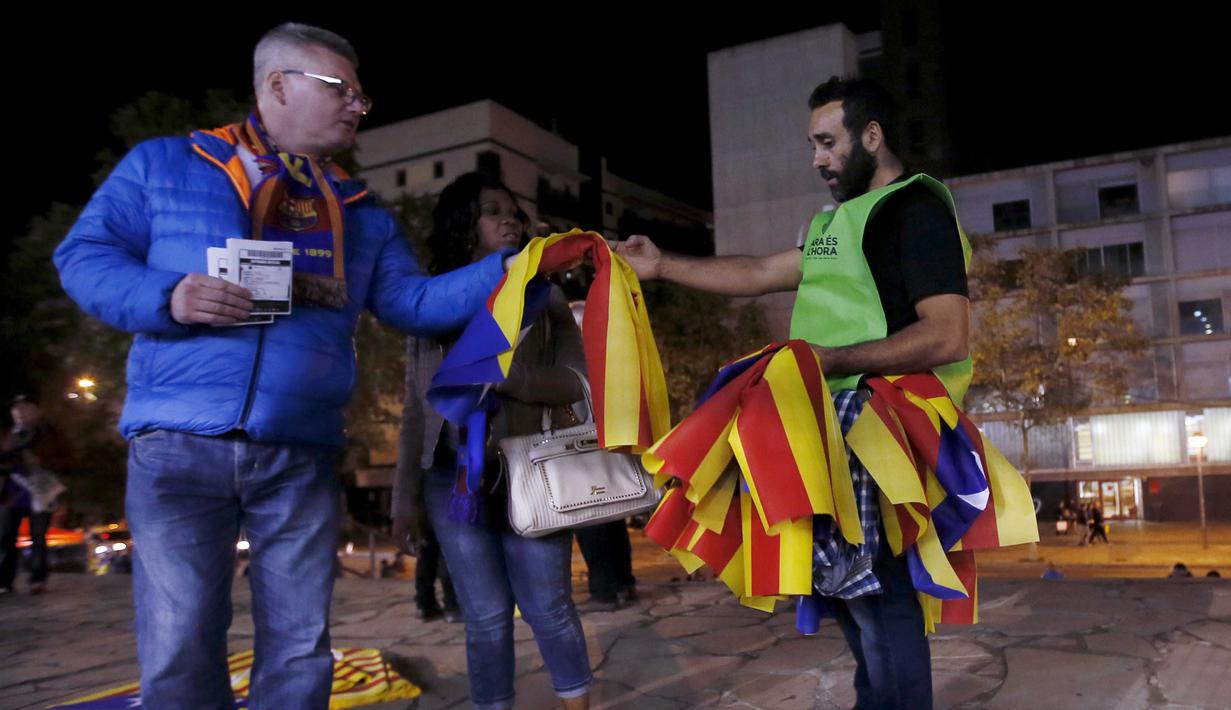 Seorang sukarelawan membagikan bendera "Estelada" (bendera separatis Catalan) sebelum laga Liga Champions grup E antara Barcelona dan Bate Borisov di Stadion Camp Nou, Barcelona, Spain, Rabu (4/11/2015). (REUTERS/Albert Gea)