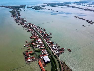 Foto yang diambil pada 30 Juli 2025 menunjukkan pemandangan udara rumah-rumah yang sebagian terendam akibat kehilangan lahan akibat perubahan iklim di Desa Bedono, Demak, Jawa Tengah. (BAY ISMOYO/AFP)