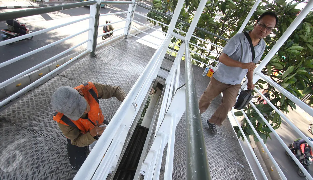 Pekerja mengecat jembatan penyeberangan menuju halte Transjakarta di kawasan Cawang, Jakarta, Rabu (5/4). Pengecatan dilakukan untuk menjaga halte agar tetap bersih dan terawat. (Liputan6.com/Immanuel Antonius)