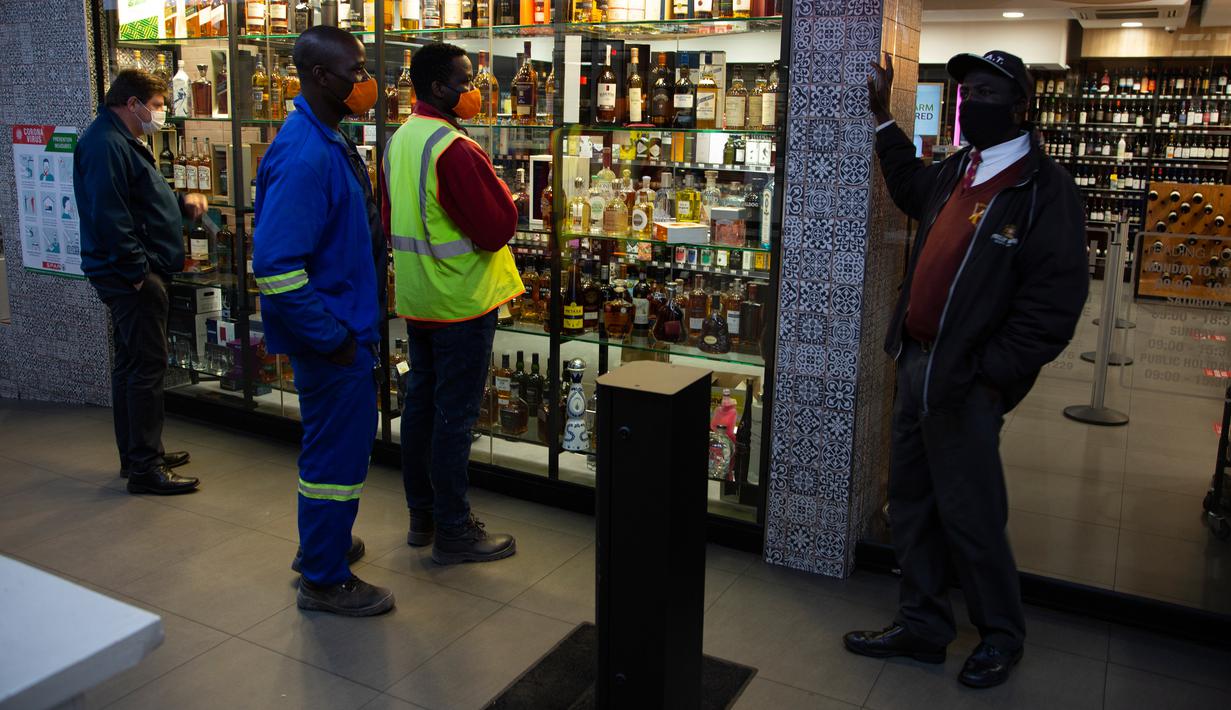 Pelanggan menunggu pembukaan kembali toko minuman keras ketika Afrika Selatan mencabut larangan penjualan alkohol dan rokok di Johannesburg, Selasa (18/8/2020). Pembelian alkohol dan rokok dilarang ketika Afrika Selatan memberlakukan lockdown ketat pada 27 Maret 2020. (AP Photo/Denis Farrell)