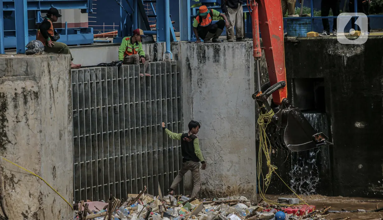 Pekerja kebersihan mengangkat sampah yang menumpuk di pintu air Manggarai, Jakarta, Selasa (22/9/2020). Tingginya curah hujan membuat kiriman sampah menumpuk di pintu air Manggarai. (Liputan6.com/Faizal Fanani)