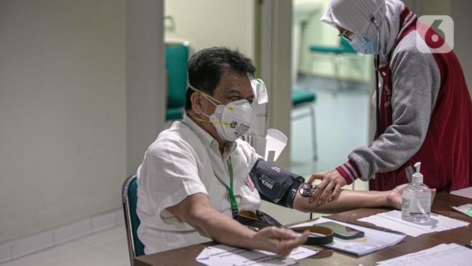 Tenaga kesehatan menjalani pemeriksaan sebelum disuntik vaksin COVID-19 produksi Sinovac oleh vaksinator saat kegiatan vaksinasi di RSCM di Jakarta, Senin (8/2/2021). Kementerian Kesehatan secara resmi memulai vaksinasi tenaga kesehatan di atas 60 tahun pada hari ini. (Liputan6.com/Faizal Fanani)