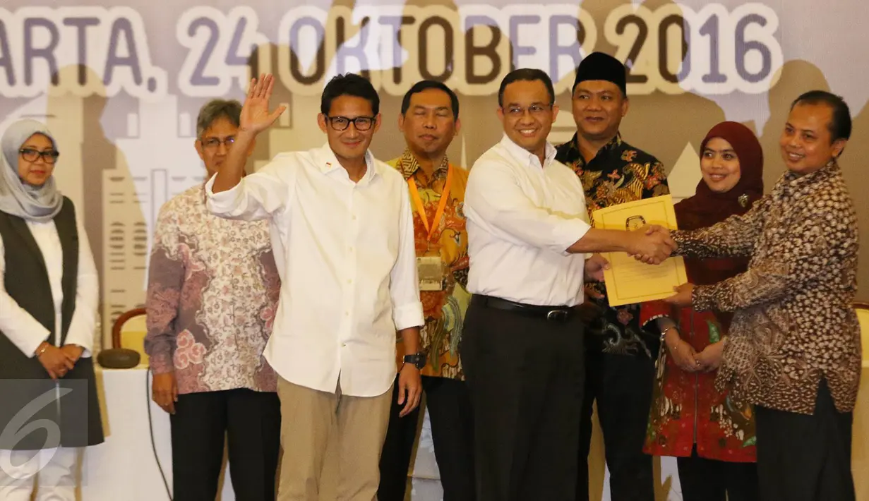 Pasangan Anies Baswedan dan Sandiaga Uno menerima berkas penetepan Cagub dan Cawagub DKI Jakarta dari Ketua KPUD DKI Sumarno saat rapat pleno terbuka penetapan calon gubernur dan wakil gubernur DKI Jakarta, Senin (24/10). (Liputan6.com/Immanuel Antonius)