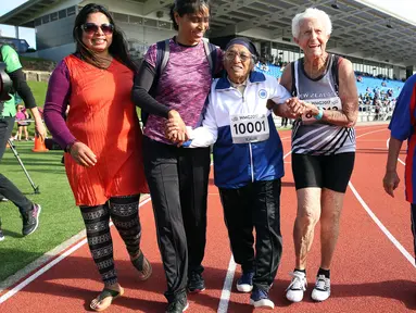 Seorang wanita berusia 101 tahun asal India, Man Kaur merayakan kemenangannya usai berkompetisi dalam lari sprint 100 meter di kategori usia 100+ di World Masters Games di Trusts Arena di Auckland (24/4). (AFP Photo/Micheal Bradley)