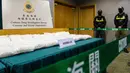Petugas Bea Cukai berjaga dekat barang bukti berupa paket berisi kristal metamfetamin atau sabu selama konferensi pers di Hong Kong, Selasa (17/12/2019). Sekitar 110 kg kristal metamfetamin atau sabu disita pada 5 Desember lalu di bandara Internasional Hong Kong. (ANTHONY WALLACE / AFP)