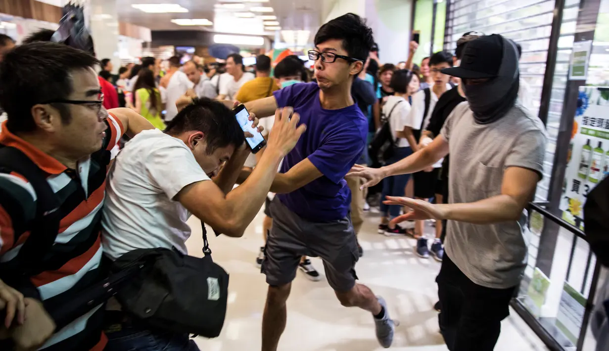 Demonstran pro-China (kiri) berkelahi dengan demonstran antipemerintah (kanan) di sebuah pusat perbelanjaan di Distrik Kowloon Bay, Hong Kong, Sabtu (14/9/2019). Bentrokan terbaru yang pecah di pusat perbelanjaan ini meluas ke jalanan di sekitarnya. (ISAAC LAWRENCE/AFP)