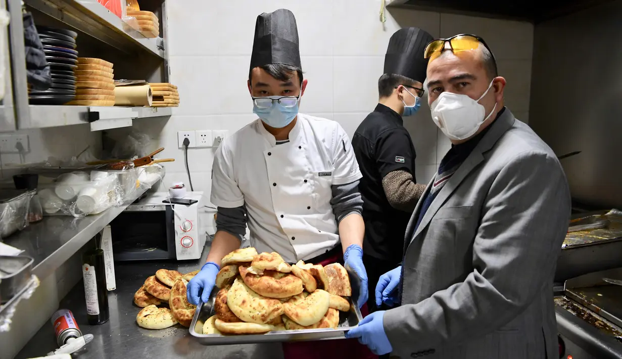 Alaaddin Colak bersama staf menyiapkan makanan gratis untuk para pekerja medis di restorannya di Fuzhou, China, 9 Februari 2020. Di tengah mewabahnya virus corona, Alaaddin dan istrinya memutuskan untuk menyediakan makanan gratis bagi para petugas pencegahan epidemi setempat. (Xinhua/Jiang Kehong)