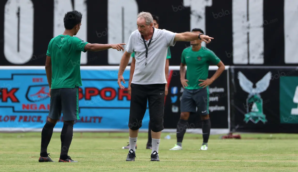 Alfred Riedl saat menjelaskan strategi menyerang kepada Bayu Pradana pada sesi latihan di Stadion Maguwoharjo, Sleman, Jumat (07/10/2016). (Bola.com/Nicklas Hanoatubun)