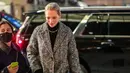 Uma Thurman memakai coat tweed oversized, ribbed turtleneck, knit cargo pants, dan kalung Roxanne Chain. (Foto: Tory Burch)