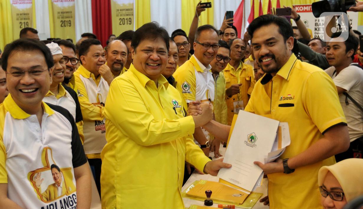 Ketua Umum Golkar Airlangga Hartarto menyerahkan berkas pendaftaran bakal calon ketua umum (caketum) Partai Golkar kepada Ketua Komite Pemilihan Maman Abdulrahman (kanan) di DPP Partai Golkar, Jakarta, Senin (2/12/2019). (Liputan6.com/Johan Tallo)