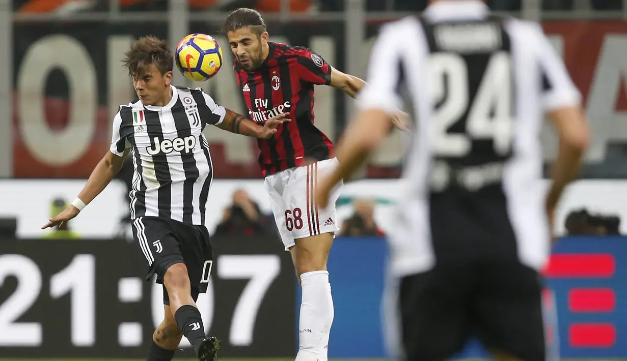 Striker Juventus, Paulo Dybala, duel udara dengan bek AC Milan, Ricardo Rodriguez, pada laga Serie A di Stadion San Siro, Sabtu (28/10/2017). AC Milan Takluk 0-2 dari Juventus. (AP/Antonio Calanni)